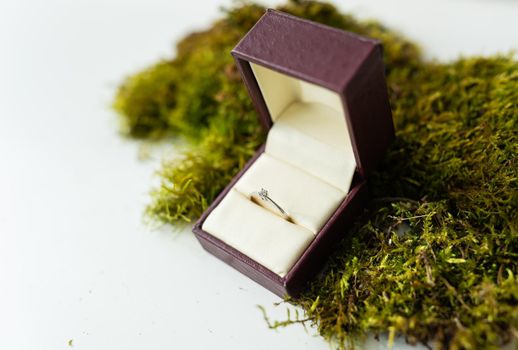 Elegant diamond ring in a box with a beige background. soft and selective focus. Marriage proposal concept