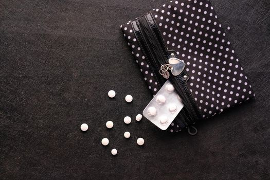 top view of white medicine and blister pack on black background .