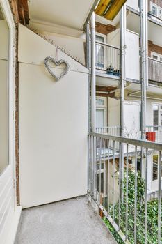 The interior of a cozy balcony with a metal fence and a view of the backyard in a modern apartment