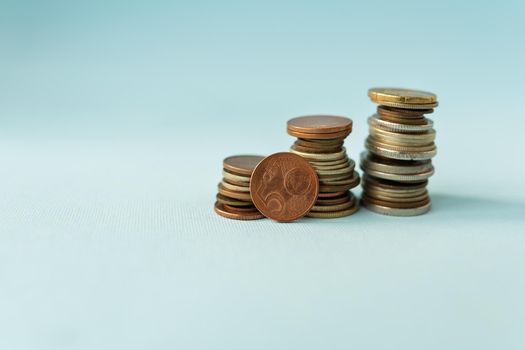 Pile of euro coins on a blue background, close-up. Place for an inscription