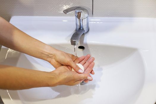 Washing hands with soap and water under the tap, close-up. Daily hygiene