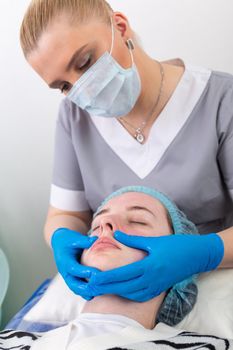 A female cosmetologist manually treats the patient's skin with a moisturizing and toning gel. The procedure helps to control the balance of fat content, restores the pH balance of the skin, gives a feeling of freshness and softness.