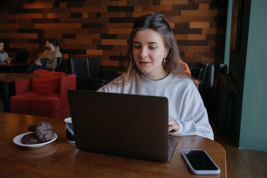 freelance woman happy working in a cafe remotely brunette