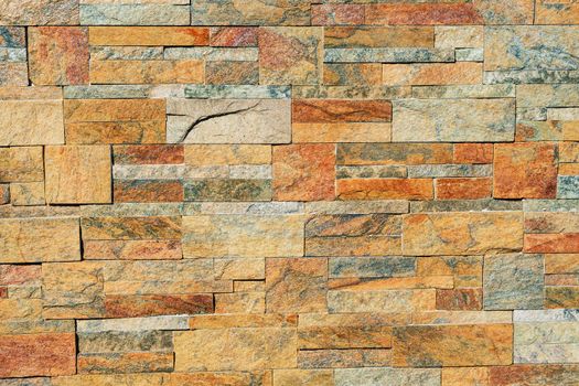 texture of a stone wall. Earth coloured slate stone background. Stone texture wall cladding for house wall. Natural outdoor light. Sunny day.