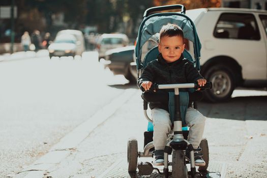 Sweet baby boy tow years old in a stroller bicycle outdoors. Little child in a pram. Infant kid in a pushchair. Spring walks with kids. High quality photo