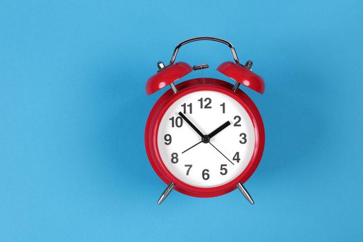 A retro red clock on a blue background