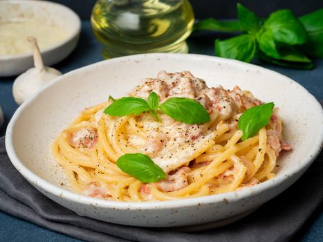 Carbonara pasta, spaghetti with pancetta, egg, parmesan cheese and cream sauce. Traditional italian cuisine. Side view, close up.