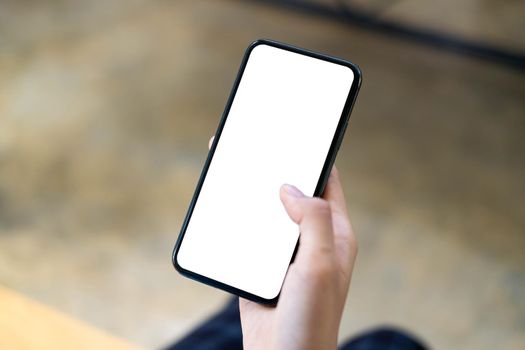 Top view Woman sitting and holding blank screen mock up mobile phone.