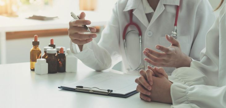 Doctor and patient discussing something while sitting at the table . Medicine and health care concept. Doctor and patient.