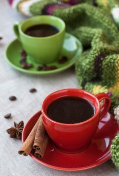 Green and red cups of coffee with coffee Bence, anise star and cinnamon Chopsticks