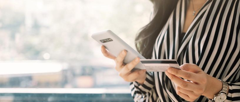 close up woman holding smartphone with credit card for pay online shopping e-commerce online payment concept