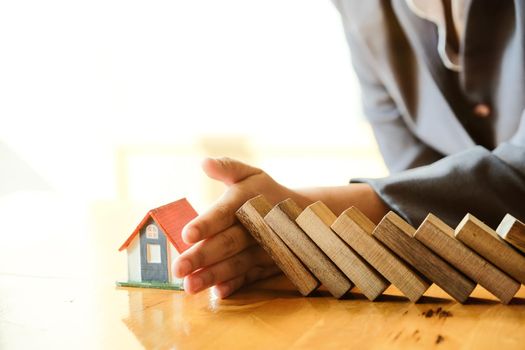 Protect the house from falling over the wooden blocks, Insurance and risk concept