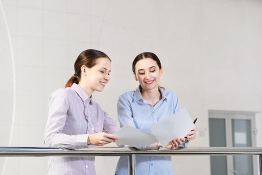 two young women discuss documents. concept of teamwork
