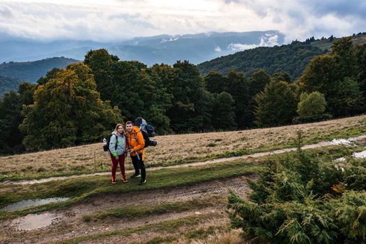Tourists walk through the Ukrainian Carpathians, tourists carry heavy backpacks on their backs, mountain trail to Mount Petros.