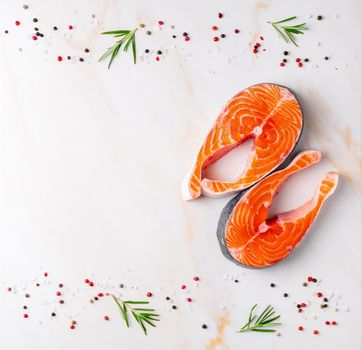 Food background, salmon steaks and seasonings on white cream marble table, flat lay, copy space.
