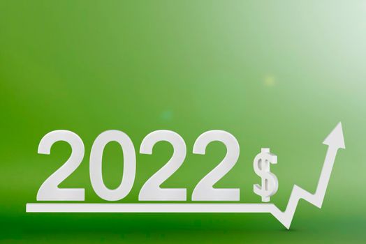 Real estate value in 2022. Rising costs of construction, insurance, rent and mortgages. inflation and rising prices. Numbers 2022 and dollar sign on up arrow, green background