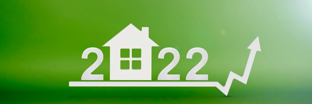 Real estate value in 2022. Rising costs of construction, insurance, rent and mortgages. inflation and rising prices. Model of a house on a green background. Numbers 2022 on up arrow.