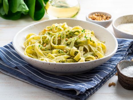 Tagliatelle pasta with pesto sauce made of Basil, garlic, pine nuts, olive oil. Side view.