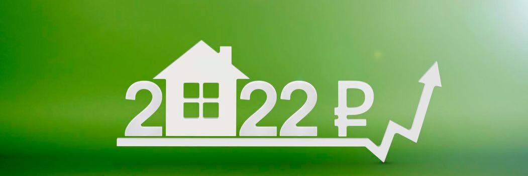Real estate value in 2022. Rising costs of construction, insurance, rent and mortgages. inflation and rising prices. Model of a house on a green background. Numbers 2022 and ruble sign on up arrow.