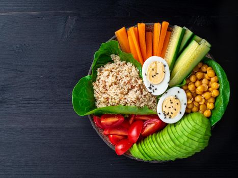 Vegetarian Buddha's bowl, a mix of vegetables. Avocado, quinoa, chickpeas, vegetables, eggs, top view, copy space.
