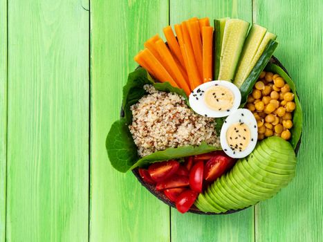 Vegetarian Buddha's bowl, a mix of vegetables. Avocado, quinoa, chickpeas, vegetables, eggs, top view, copy space.