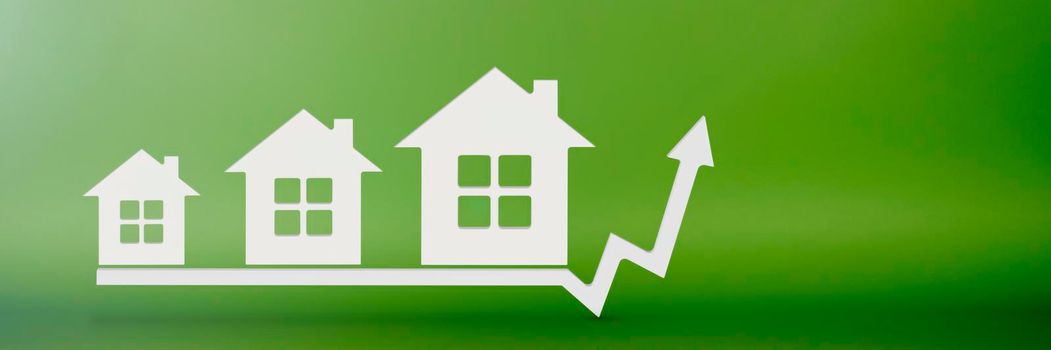 Real estate, cost and choice of house. House model on a green background. The concept of insurance or buying real estate on credit. Choosing a house or renting an apartment. Graph up arrow.