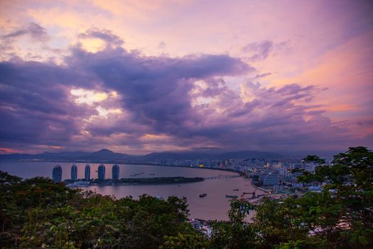 Evening skyscrapers on the sea bay with blue clouds