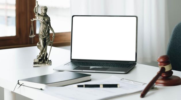 Workspace of lawyer with laptop blank white screen and law wooden gavel,legal book and brass scale of judge. lawyer and law ,judiciary and legislature courtroom legal concept..