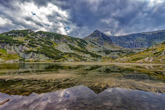Beautiful landscape of mountain lake with algae in Rila mountain, Bulgaria