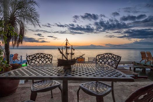 A table and chairs with decoration at sunrise at the sea beach