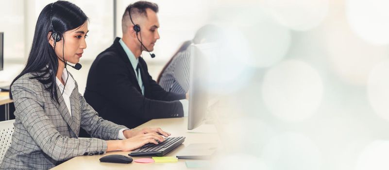 Business people wearing headset working in office to support remote customer or colleague. Call center, telemarketing, customer support agent provide service in broaden view .