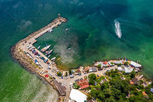 Aerial top view from drone to the seacoast and the marina with boats and yachts. Sea landscape with yachts from above