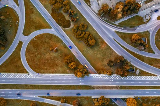 Aerial top view of the modern highway road intersection in autumn. Drone photography.