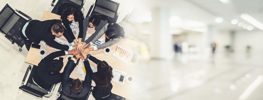 Happy business people celebrate teamwork success together with joy at office table shot from top view . Young businessman and businesswoman workers express cheerful victory in broaden view .