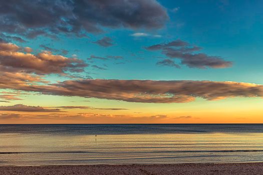 Beautiful colorful clouds over the sea. Amazing sky after sunset.