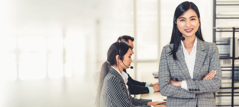 Business people wearing headset working in office to support remote customer or colleague. Call center, telemarketing, customer support agent provide service in broaden view .