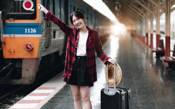 Young traveler woman looking for friend planning trip at train station. Summer and travel lifestyle concept.