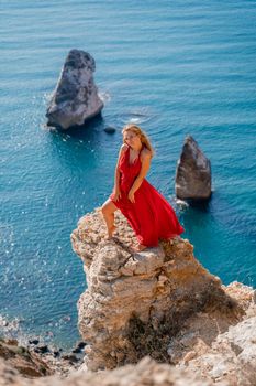 A woman in a red flying dress fluttering in the wind, against the backdrop of the sea