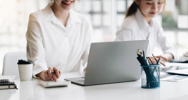 Business People Meeting using laptop computer, calculator,notebook,stock market chart paper for analysis Plans to improve quality next month. Conference Discussion Corporate Concept.