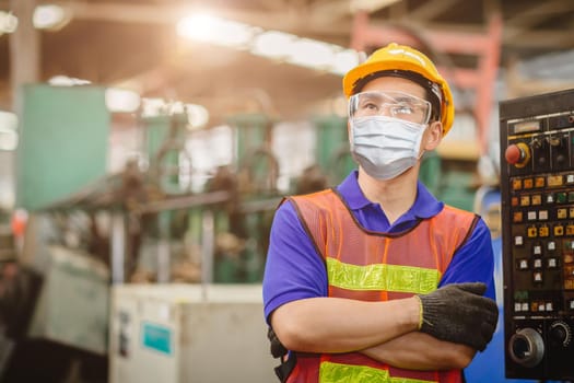 Asian worker wearing disposable face mask or HEPA face shield for protection from Coronavirus(Covid-19) spreading and toxic smoke dust air pollution in factory for labor health care.