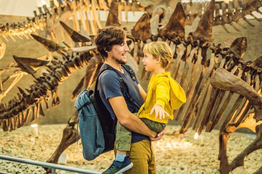 Beijing China, October 16, 2018: Dad and boy watching dinosaur skeleton in museum.