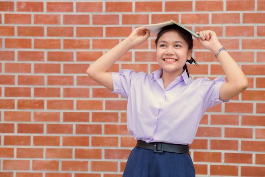 Asian girl teen student uniform happy smile with book for education back to school concept.