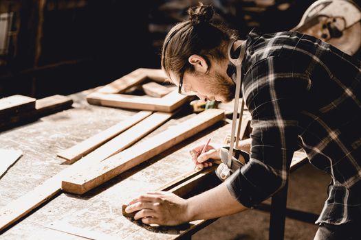 Carpenter man making masterpiece woodworks handcraft furniture in wood workshop.
