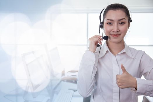 Portrait Asian callcenter operator thumbs up. Helpdesk support phone call customer care female staff smiling with headset good service concept with space for banner background.