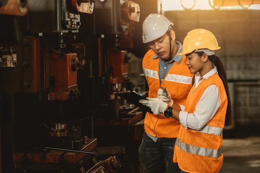 Engineer team male working with women work help support together in heavy industry teach and training machine operation in factory