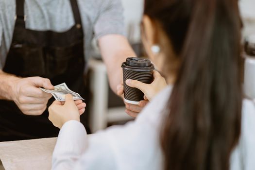 people buying a cup of coffee with fake banknote money payment at the cafe