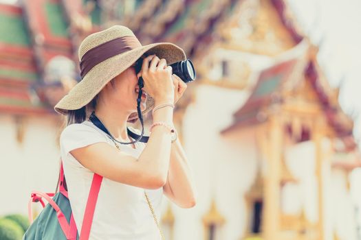 Girl teen travel in Thailand. Tourist take a photograph in Temple in Asian country vintage leisure lifestyle in holiday.