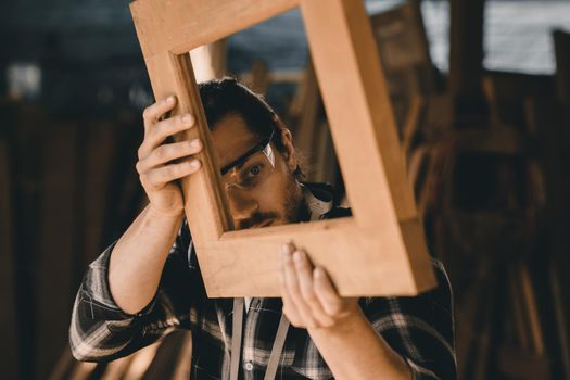 The carpenters man high experienced wood worker making furniture. master of woodcraft male looking at workpiece closeup with fine detail.