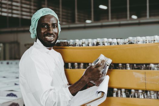 Black African worker working in industry factory products checking inventory stock in the warehouse. portrait looking camera smiling.