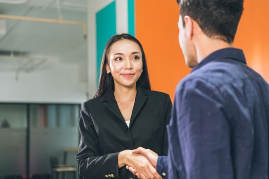 Business women greeting meet a man hand shaking smiling contact for project partner in the office.